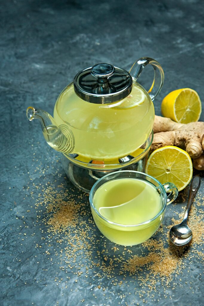 lemon tea benefits in a cup with sliced lemon and herbs