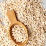 oat flour in a wooden bowl with oats around