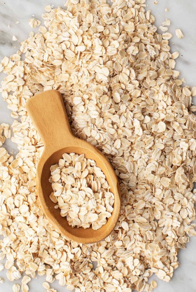 oat flour in a wooden bowl with oats around